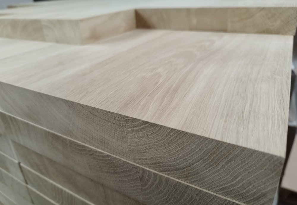 Een stapel massief eiken planken van 40 mm, van opzij: de jaarringen lopen dwars door het hout heen