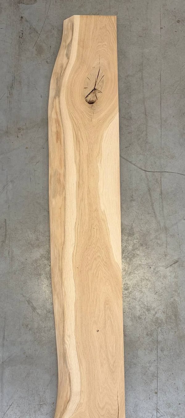 Ruwe eiken plank rechtop tegen de muur van het atelier