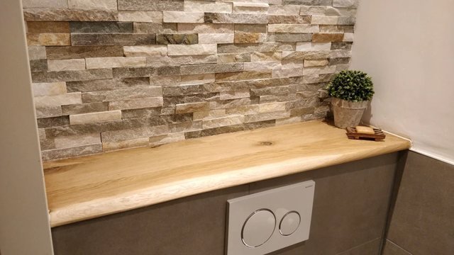 Een massief eiken plank boven een toilet, met een natuurlijke rand